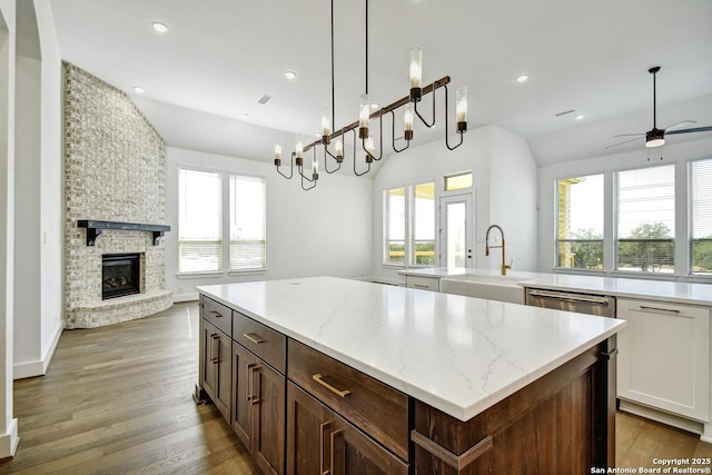 409 Dulce Vis, Boerne, TX 78006 - kitchen featuring a center island, open floor plan, a large fireplace, wood finished floors, and recessed lighting