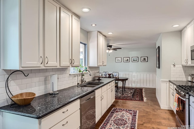 547 Patricia, San Antonio, TX 78216 - kitchen featuring stainless steel appliances, dark wood-style floors, wainscoting, a ceiling fan, and white cabinetry