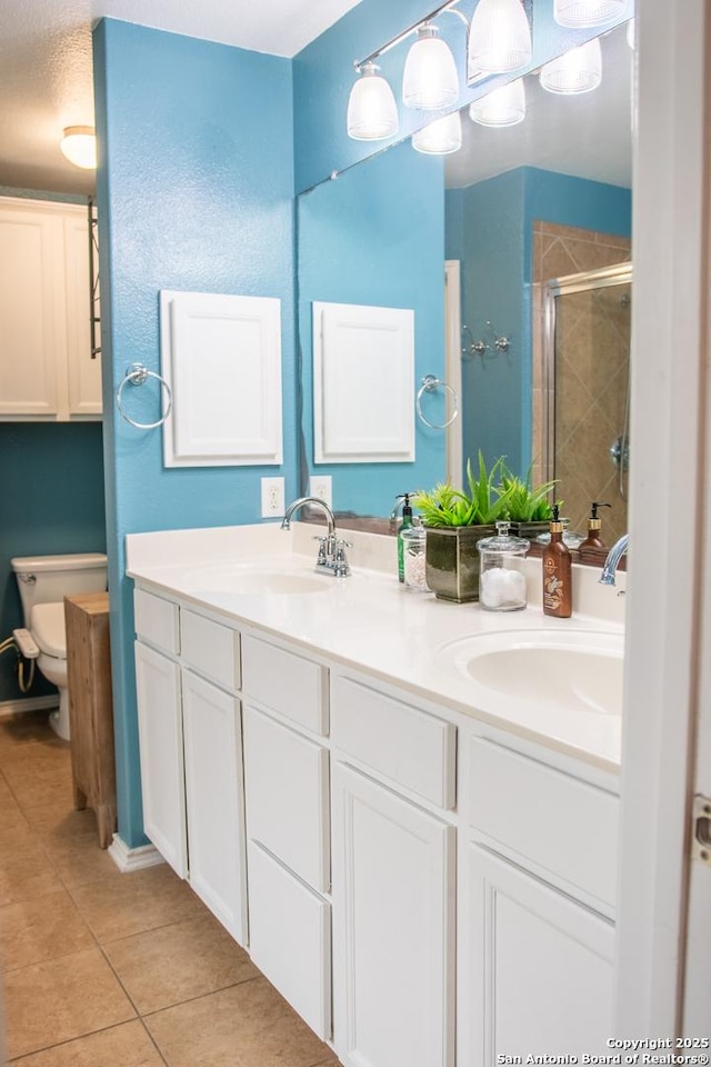 12339 Craddick Cv, San Antonio, TX 78254 - bathroom with tile patterned floors, a shower stall, and double vanity