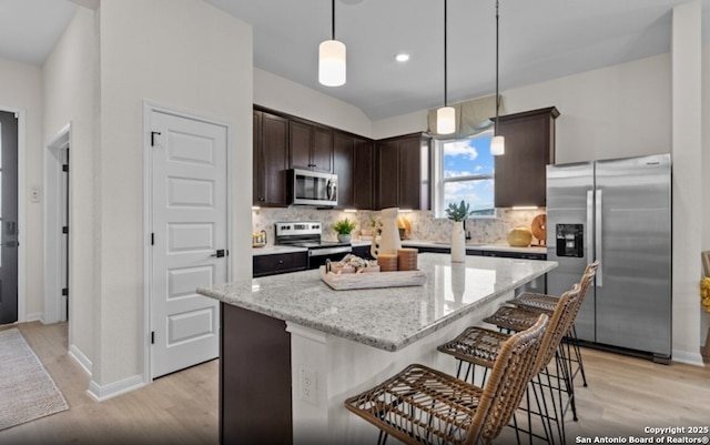 6651 Comanche Vly, San Antonio, TX 78233 - kitchen featuring appliances with stainless steel finishes, dark brown cabinets, light wood-style floors, tasteful backsplash, and recessed lighting