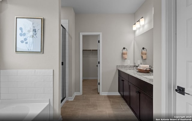 6651 Comanche Vly, San Antonio, TX 78233 - bathroom with double vanity, a shower stall, a garden tub, and a walk in closet