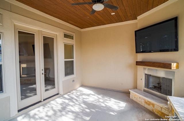 12 Denbury Gln, San Antonio, TX 78257 - unfurnished living room featuring wooden ceiling, exterior fireplace, ceiling fan, carpet floors, and ornamental molding