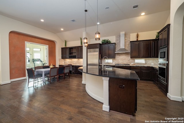 12 Denbury Gln, San Antonio, TX 78257 - kitchen featuring wall chimney exhaust hood, stainless steel appliances, open shelves, dark brown cabinetry, and vaulted ceiling