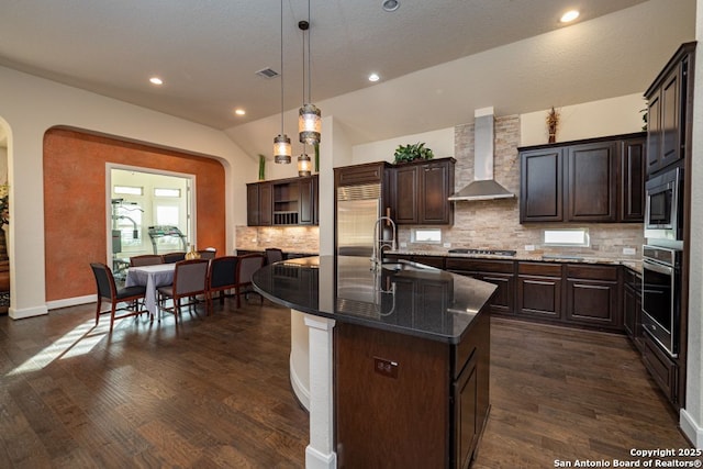 12 Denbury Gln, San Antonio, TX 78257 - kitchen with wall chimney exhaust hood, built in appliances, tasteful backsplash, dark brown cabinets, and vaulted ceiling