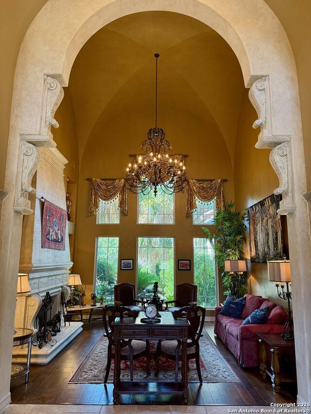 107 Geddington, Shavano Park, TX 78249 - dining area featuring hardwood / wood-style flooring, a high ceiling, a chandelier, arched walkways, and healthy amount of natural light