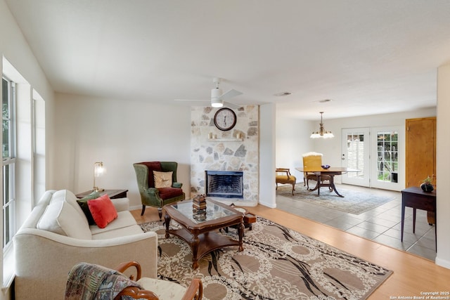 2743 Fairview, Canyon Lake, TX 78133 - living area featuring a stone fireplace, wood finished floors, a chandelier, and ceiling fan