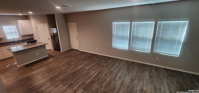 7115 Mesa Clfs, Converse, TX 78109 - kitchen with dark wood-type flooring, white cabinets, a center island, and recessed lighting