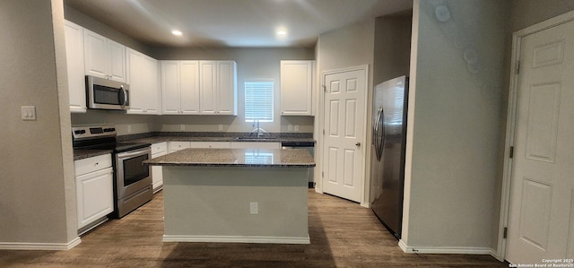 7115 Mesa Clfs, Converse, TX 78109 - kitchen featuring appliances with stainless steel finishes, white cabinets, dark wood-style flooring, a kitchen island, and recessed lighting