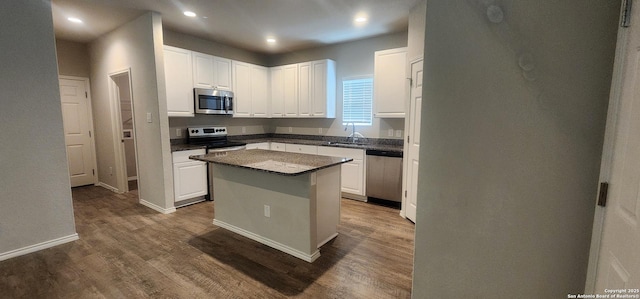 7115 Mesa Clfs, Converse, TX 78109 - kitchen with appliances with stainless steel finishes, dark wood-type flooring, white cabinets, recessed lighting, and a center island