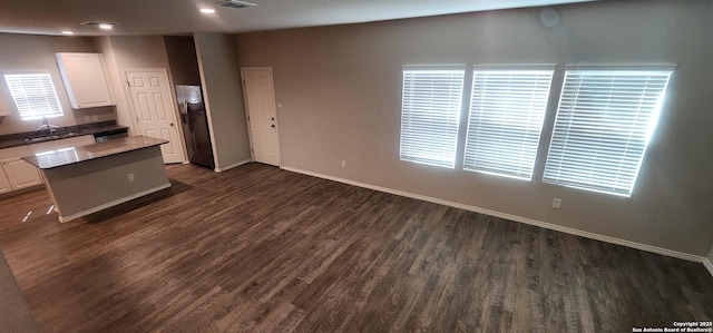 7115 Mesa Clfs, Converse, TX 78109 - kitchen featuring white cabinetry, dark wood finished floors, a kitchen island, fridge with ice dispenser, and recessed lighting