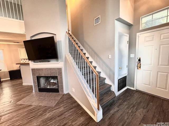 6914 Sandy Pt, San Antonio, TX 78244 - foyer featuring a high ceiling, wood finished floors, a tile fireplace, and stairway