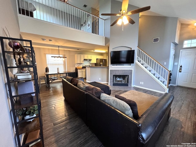 6914 Sandy Pt, San Antonio, TX 78244 - living area with a high ceiling, dark wood-style flooring, a ceiling fan, a fireplace, and stairway