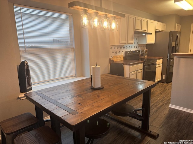 6914 Sandy Pt, San Antonio, TX 78244 - kitchen featuring black electric range, stainless steel fridge, dark wood-style flooring, white cabinetry, and under cabinet range hood