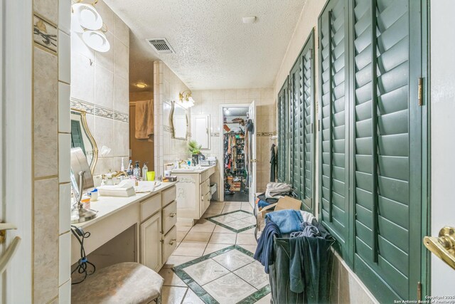 2102 Border Ml, San Antonio, TX 78230 - full bathroom with tile patterned floors, inlaid floor details, vanity, a textured ceiling, and a spacious closet