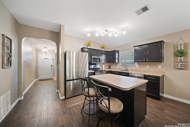 10410 Appaloosa Bay, San Antonio, TX 78254 - kitchen featuring appliances with stainless steel finishes, arched walkways, light countertops, dark wood-type flooring, and a breakfast bar area