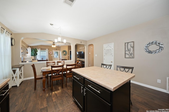 10410 Appaloosa Bay, San Antonio, TX 78254 - kitchen featuring arched walkways, dark cabinets, a kitchen island, light countertops, and a breakfast bar area