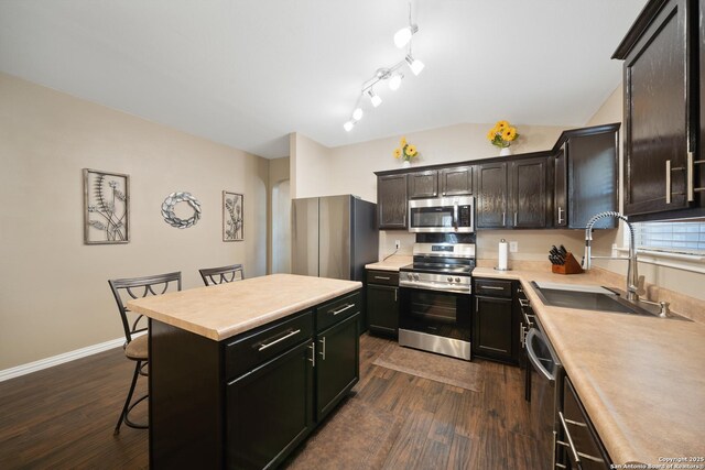 10410 Appaloosa Bay, San Antonio, TX 78254 - kitchen featuring appliances with stainless steel finishes, dark wood-style floors, light countertops, a breakfast bar area, and vaulted ceiling