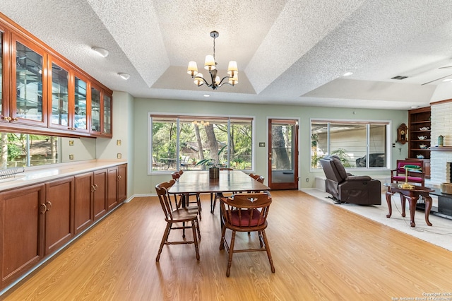 3523 Red Oak, San Antonio, TX 78230 - dining area with light wood finished floors, healthy amount of natural light, a textured ceiling, a chandelier, and a raised ceiling