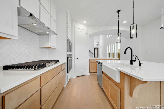 233 Alpine, New Braunfels, TX 78130 - kitchen featuring appliances with stainless steel finishes, exhaust hood, arched walkways, recessed lighting, and decorative backsplash