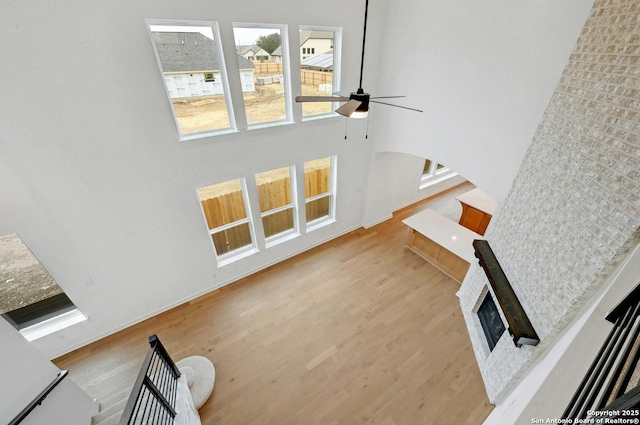 233 Alpine, New Braunfels, TX 78130 - staircase with ceiling fan, wood finished floors, a fireplace, and a high ceiling