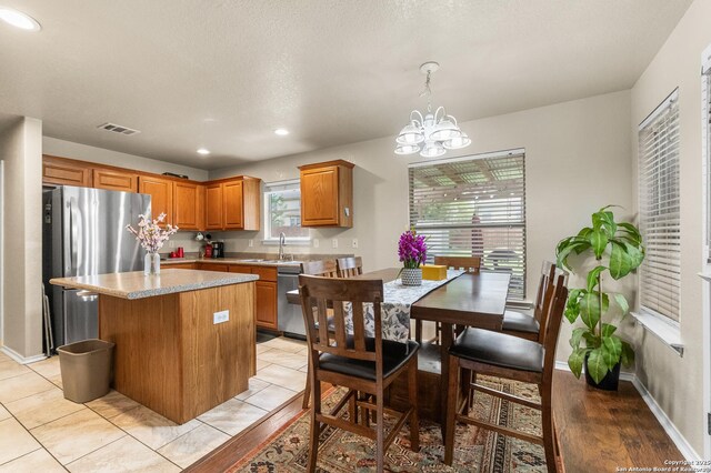 10223 Cactus Vly, San Antonio, TX 78254 - kitchen with appliances with stainless steel finishes, a kitchen island, a chandelier, brown cabinetry, and recessed lighting