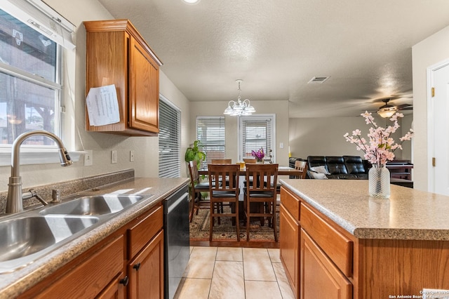 10223 Cactus Vly, San Antonio, TX 78254 - kitchen featuring stainless steel dishwasher, brown cabinets, open floor plan, a chandelier, and pendant lighting