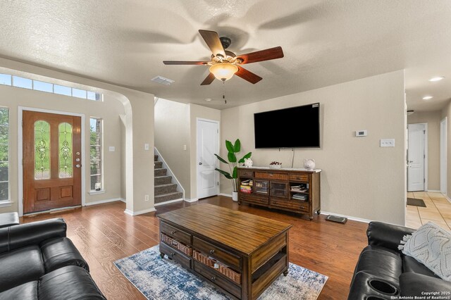 10223 Cactus Vly, San Antonio, TX 78254 - living area featuring ceiling fan, stairs, light wood finished floors, a textured ceiling, and arched walkways