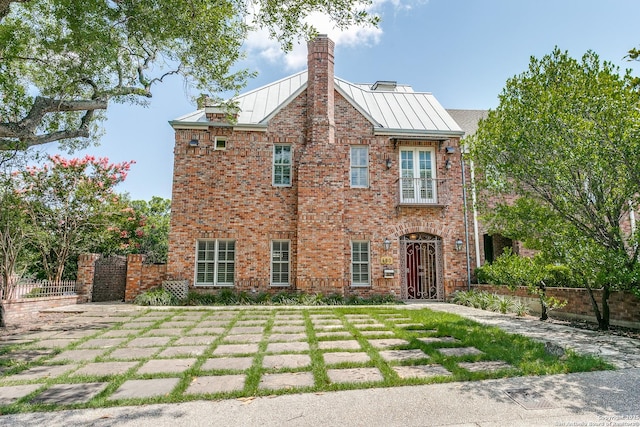 600 Thelma, Olmos Park, TX 78212 - view of front facade featuring a standing seam roof, a chimney, brick siding, a gate, and a metal roof
