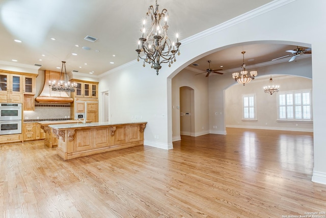 600 Thelma, Olmos Park, TX 78212 - kitchen with a ceiling fan, custom range hood, double oven, arched walkways, and a chandelier