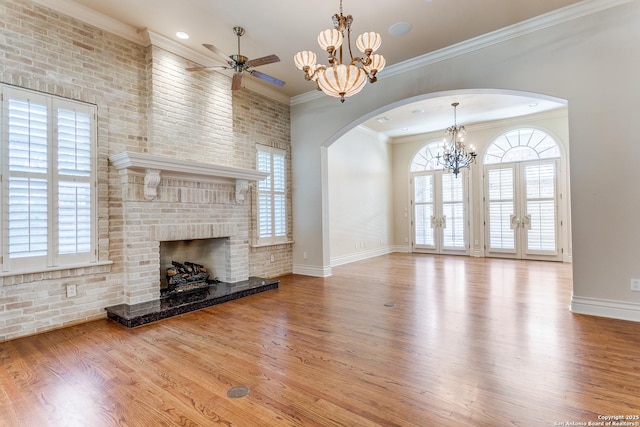 600 Thelma, Olmos Park, TX 78212 - unfurnished living room featuring arched walkways, a ceiling fan, a brick fireplace, a chandelier, and wood finished floors