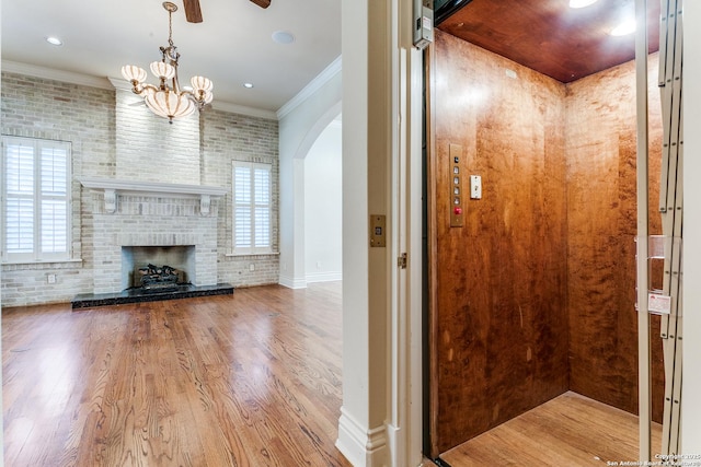 600 Thelma, Olmos Park, TX 78212 - unfurnished living room featuring elevator, arched walkways, wood finished floors, crown molding, and a brick fireplace