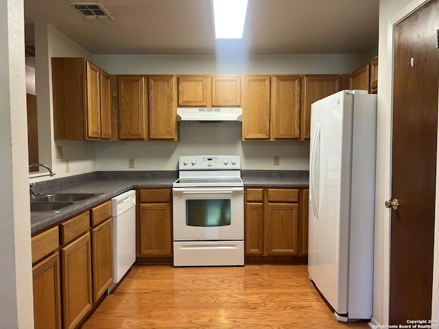 1503 Jami, Pleasanton, TX 78064 - kitchen featuring white appliances, under cabinet range hood, dark countertops, and brown cabinets