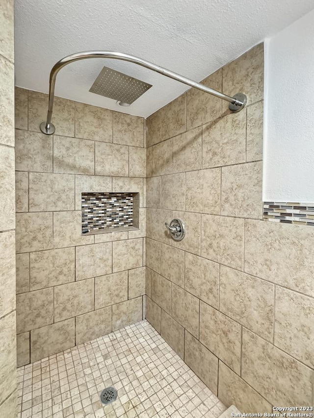 102 Aganier Ave, San Antonio, TX 78212 - bathroom with a tile shower and a textured ceiling