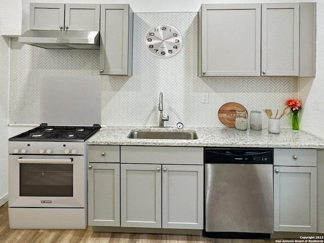 102 Aganier Ave, San Antonio, TX 78212 - kitchen featuring stainless steel dishwasher, white range with gas cooktop, under cabinet range hood, gray cabinets, and backsplash