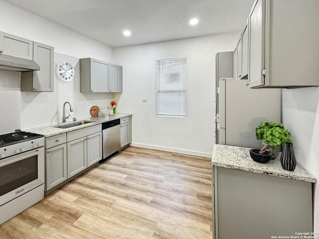 102 Aganier Ave, San Antonio, TX 78212 - kitchen with white appliances, gray cabinetry, exhaust hood, light wood-style floors, and tasteful backsplash