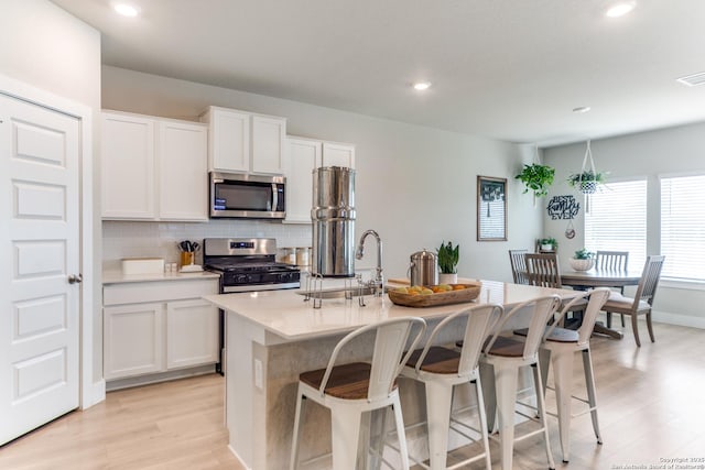 29125 Rock Cyn, Bulverde, TX 78163 - kitchen with appliances with stainless steel finishes, light wood-type flooring, backsplash, recessed lighting, and a kitchen breakfast bar