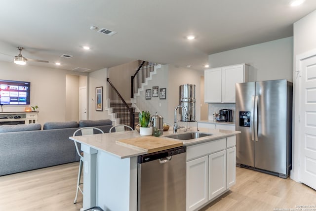 29125 Rock Cyn, Bulverde, TX 78163 - kitchen featuring stainless steel appliances, light wood-type flooring, open floor plan, a center island with sink, and white cabinets