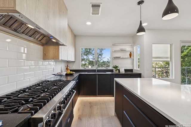 305 Joliet Unit D, San Antonio, TX 78209 - kitchen with custom range hood, stainless steel stove, plenty of natural light, decorative backsplash, and recessed lighting