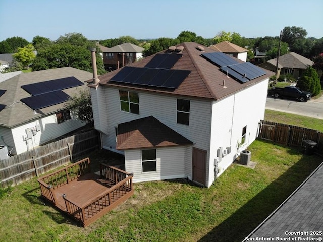 5615 Camry Spgs, San Antonio, TX 78251 - back of house featuring a fenced backyard, a wooden deck, solar panels, and a shingled roof