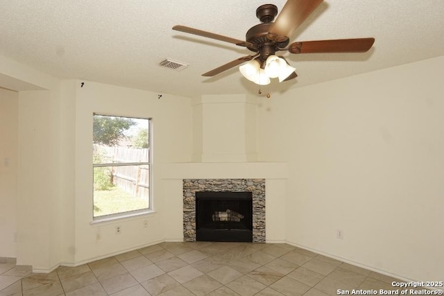 5615 Camry Spgs, San Antonio, TX 78251 - unfurnished living room featuring a ceiling fan, light tile patterned flooring, a stone fireplace, and a textured ceiling