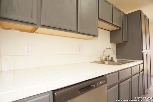 5615 Camry Spgs, San Antonio, TX 78251 - kitchen with stainless steel dishwasher, tile counters, and gray cabinets