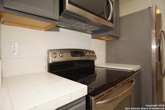 5615 Camry Spgs, San Antonio, TX 78251 - kitchen featuring stainless steel appliances, tile counters, and backsplash