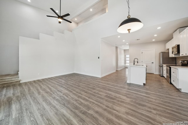 818 Martin Luther King, San Antonio, TX 78203 - unfurnished living room featuring recessed lighting, wood finished floors, ceiling fan, and a towering ceiling