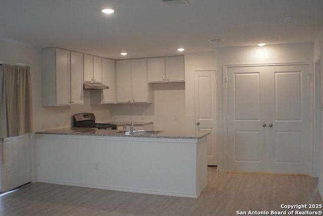7119 Satellite Way, San Antonio, TX 78252 - kitchen featuring stove, a peninsula, light wood-style flooring, light stone countertops, and recessed lighting