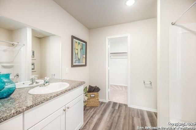 212 Agave Cir, Jourdanton, TX 78026 - full bath featuring wood finished floors, vanity, a walk in closet, and recessed lighting