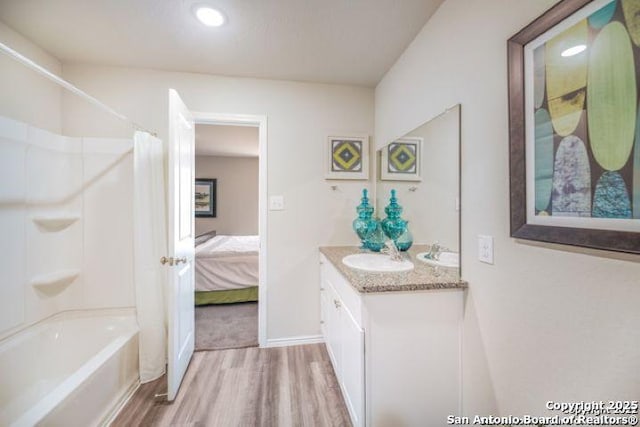 212 Agave Cir, Jourdanton, TX 78026 - full bath featuring wood finished floors, double vanity, shower / tub combo with curtain, connected bathroom, and recessed lighting