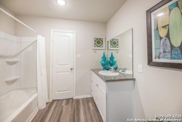 212 Agave Cir, Jourdanton, TX 78026 - full bath with wood finished floors, double vanity, shower / bath combination with curtain, and recessed lighting