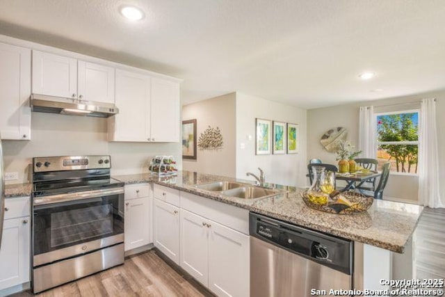 212 Agave Cir, Jourdanton, TX 78026 - kitchen with appliances with stainless steel finishes, under cabinet range hood, a peninsula, plenty of natural light, and recessed lighting