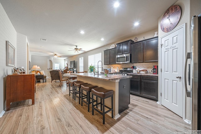 6018 Pearl Pass, San Antonio, TX 78222 - kitchen featuring appliances with stainless steel finishes, a kitchen breakfast bar, open floor plan, ceiling fan, and an island with sink