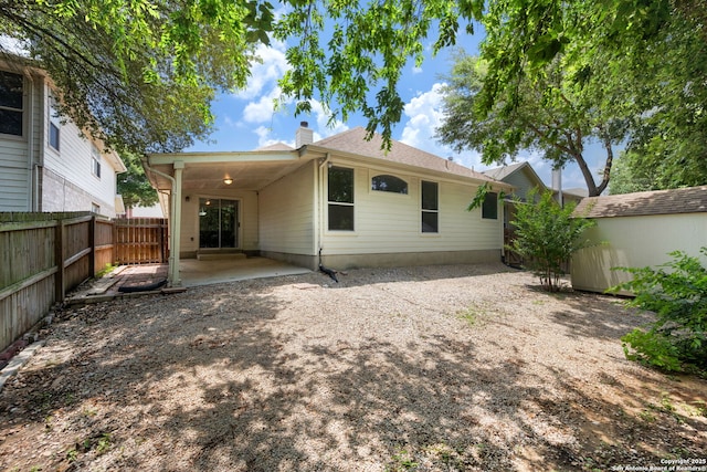 1905 Walter Raleigh, Windcrest, TX 78239 - back of house featuring a chimney, a patio area, a fenced backyard, and a storage unit